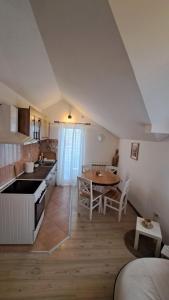 a kitchen and dining room with a table and chairs at Apartman NEVA in Bele Vode