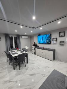 a dining room with a table and a tv on a wall at Albicocche house Catania in Catania