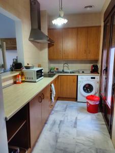 eine Küche mit Holzschränken und einer weißen Mikrowelle in der Unterkunft Apartamentos La Bola 94 in Ronda