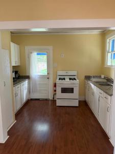 a kitchen with white cabinets and a stove at Blue Moon Guest House in Lafayette