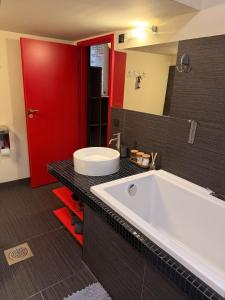 塔林Cozy loft in the heart of Old Town的浴室里有一个大浴缸和一扇红门