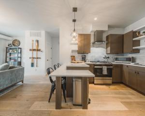 een keuken met houten kasten en een tafel met stoelen bij Whitefish Loft Downtown Condo for 6 in Outback Mobile Home Settlement