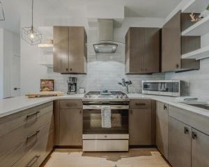 een keuken met houten kasten en een kookplaat met oven bij Whitefish Loft Downtown Condo for 6 in Outback Mobile Home Settlement +12 foto's