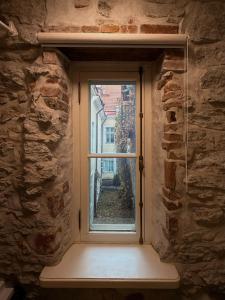 塔林Cozy loft in the heart of Old Town的石墙上的一扇窗户，带有窗台