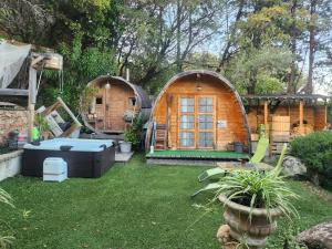 ein Hinterhof mit zwei kleinen Häusern und einem Whirlpool in der Unterkunft Cabane Sauna & Jacuzzi Hiver in Vaccili