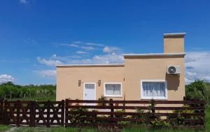 ein Haus mit einem Zaun davor in der Unterkunft Los Cardales Casa Quinta con Pileta in Esquina