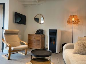 een woonkamer met een bank, een stoel en een tafel bij Le Gîte du Pèlerin avec piscine in Florennes