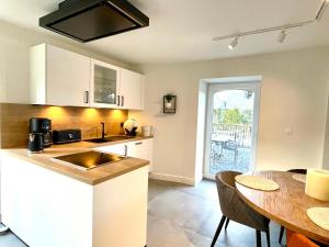 een keuken en eetkamer met een tafel en een aanrecht bij Le Gîte du Pèlerin avec piscine in Florennes