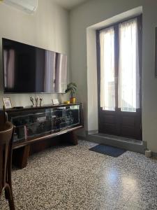 a living room with a large television and a door at Casa Piazzetta - Lake Como WiFi & A-C in Dorio