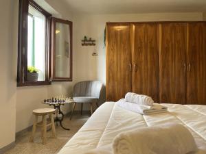 a bedroom with a bed and a chair and a table at Casa Piazzetta - Lake Como WiFi & A-C in Dorio