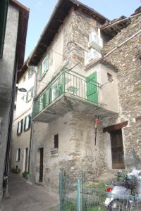 a building with a balcony on the side of it at Casa Piazzetta - Lake Como WiFi & A-C in Dorio