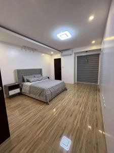 une chambre avec un lit et un parquet dans l'établissement 4 Bedroom House for 5-6 guests, à Manille