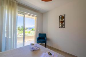 a bedroom with a bed and a blue chair and a window at Residence A Marina in Lumio +54 photos
