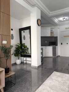 a living room with a clock on a wall at Vitamin Sea Apartment in Akouda
