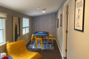 a small room with a table and a yellow chair at Wildlife with style in the mountains in Stanley