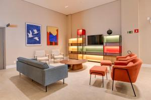 カラグアタトゥーバにあるHampton By Hilton Caraguatatuba Serramarのソファと椅子とテレビのあるリビングルーム