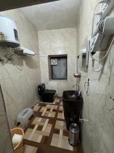 a bathroom with a black toilet and a sink at Ufo Mussoorie in Mussoorie
