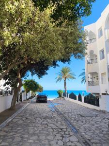 a cobblestone street with a car parked on the beach at Vitamin Sea Apartment in Akouda