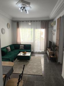 a living room with a green couch and a table at Vitamin Sea Apartment in Akouda +21 photos