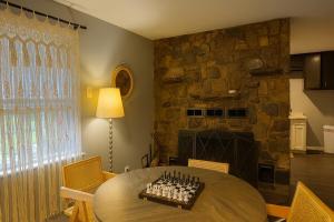 a dining room with a table and a stone fireplace at Wildlife with style in the mountains in Stanley