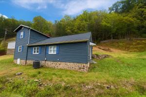 a blue house sitting on top of a grass field at Wildlife with style in the mountains in Stanley
