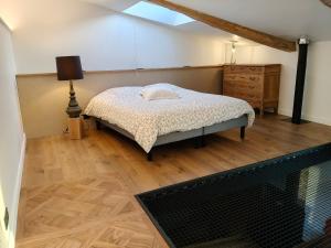 a bedroom with a bed and a dresser at Gîte du Volcan des Causses in Saint-Jean-dʼAlcapiès
