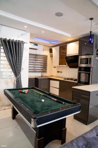 a kitchen with a pool table in a room at Gillant Luxury Homes in Benin City