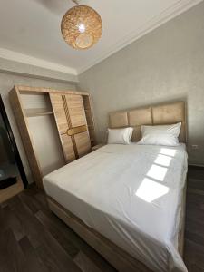une chambre avec un grand lit avec des draps blancs dans l'établissement Ocean Escape 5 min tgv, à Tanger