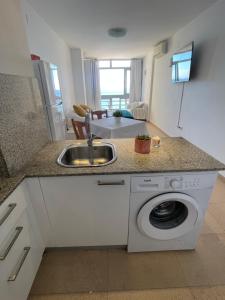 a kitchen with a sink and a washing machine at &luxe vista mar& in Calpe