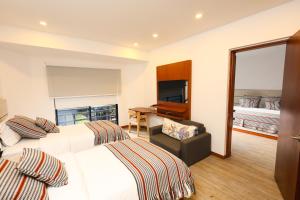 a hotel room with two beds and a desk at Hotel Casa PARDO Boutique in Bogotá