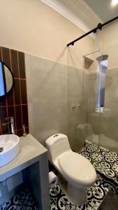 a bathroom with a toilet and a sink and a shower at Bendito Hostels in Bogotá +57 photos