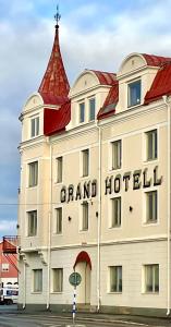 a large white building with a red roof at Grand Hotell & Hostel Strömsund in Strömsund