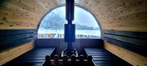 a room with benches and a large window in a cabin at Liten gårdshytte til leie in Åseral