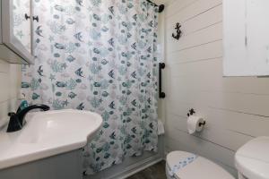 een badkamer met een wastafel en een douchegordijn bij Beach Retreat in Edisto Island +24 foto's