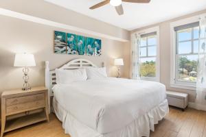 a white bedroom with a white bed and two windows at Observation Point North 456 in Destin
