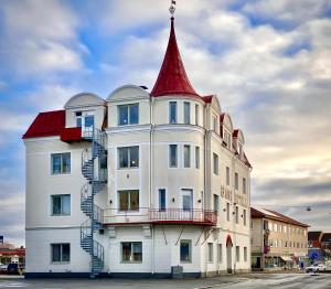 a white building with a red tower on top of it at Grand Hotell & Hostel Strömsund in Strömsund
