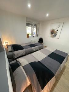 a bedroom with two beds and a painting on the wall at Appartement agréable et moderne - Rez de chaussée - Blainville Sur L'Eau in Blainville-sur-lʼEau