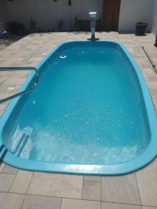 Un gran jacuzzi azul en un patio. en Casa perto da Praia do Laranjal, en Pelotas