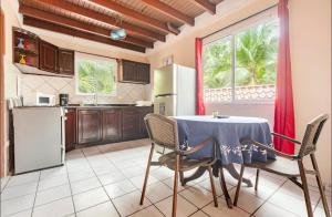 a kitchen with a table and chairs and a kitchen with a refrigerator at Hotel Beachfront Vista Hermosa in Jacó