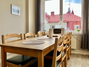 a dining room table and chairs with a window at Grand Hotell Strömsund in Strömsund
