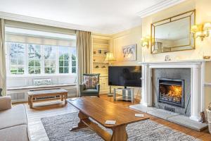 ein Wohnzimmer mit Kamin und Fernseher in der Unterkunft Little Barwick in Stanhoe