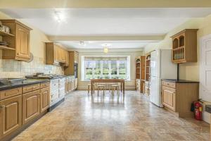 eine große Küche mit Holzschränken und einem Tisch in der Unterkunft Little Barwick in Stanhoe + 20 Fotos