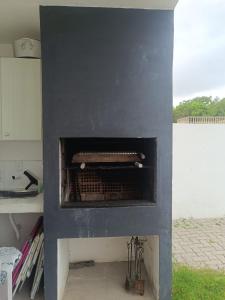 una chimenea azul con estufa en una habitación en Casa perto da Praia do Laranjal, en Pelotas