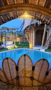a pool in a house with chairs and a chandelier at manta family sidemen in Selat