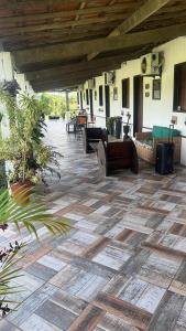 an outdoor patio with a wooden floor and furniture at Pousada Metropolitana Salvador in Candeias