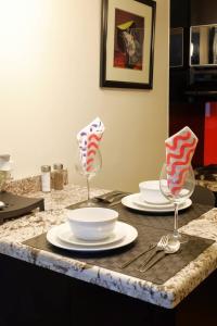 Ein Tisch mit Tellern und Weingläsern auf einer Theke in der Unterkunft Lovely and Cozy Apartment in Colonia Cañón Doña Petra