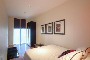 ein Schlafzimmer mit einem Bett und drei Bildern an der Wand in der Unterkunft Lovely and Cozy Apartment in Colonia Cañón Doña Petra