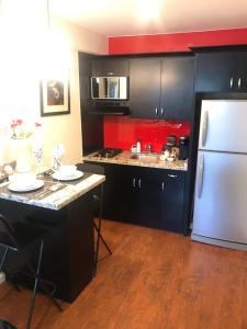 eine Küche mit schwarzen Schränken und einem weißen Kühlschrank in der Unterkunft Lovely and Cozy Apartment in Colonia Cañón Doña Petra + 10 Fotos