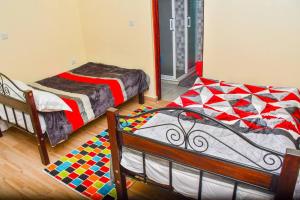 - une chambre avec 2 lits et un tapis au sol dans l'établissement Garden lodge near Ngong with forest walks - 2340, à Kiserian