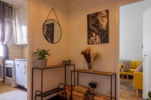 een woonkamer met twee tafels en een spiegel aan de wand bij Centre Lausanne in Lausanne